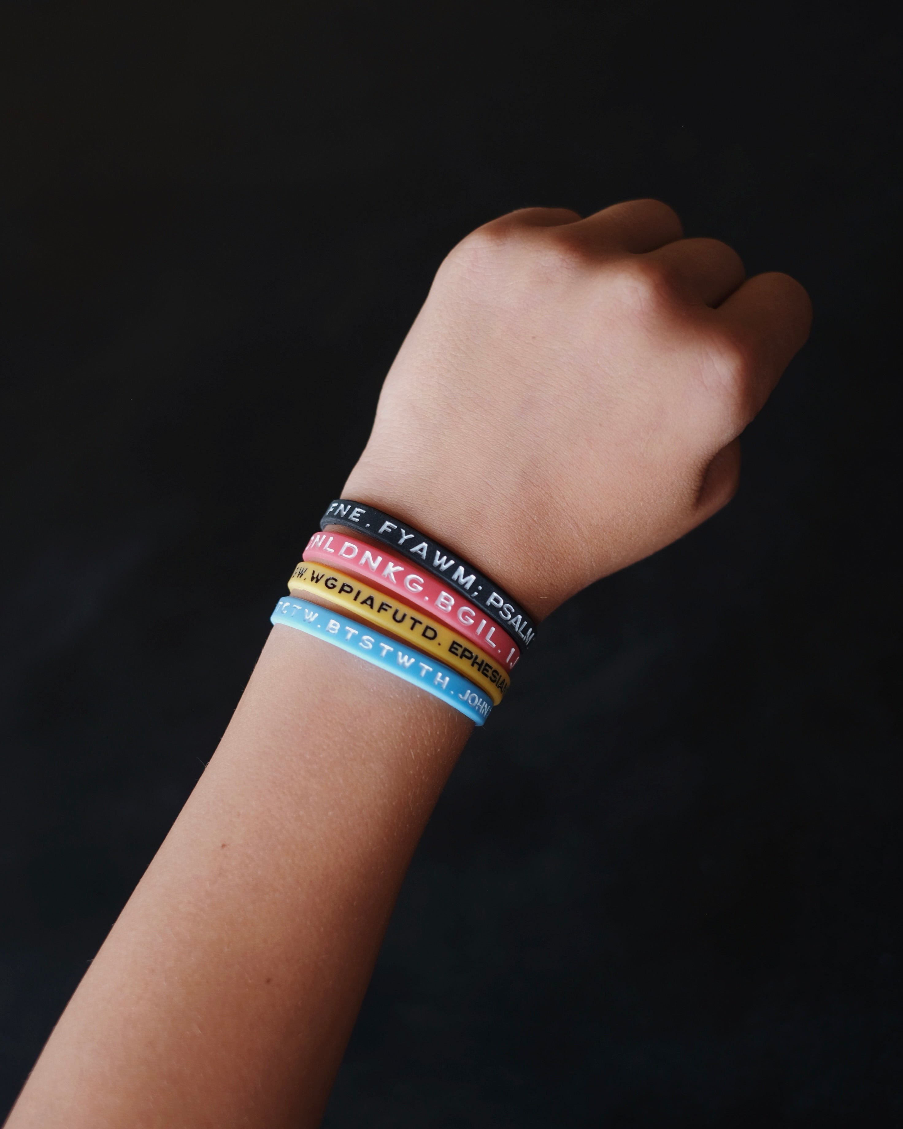 Four Bible Memory Project wristbands on a wrist