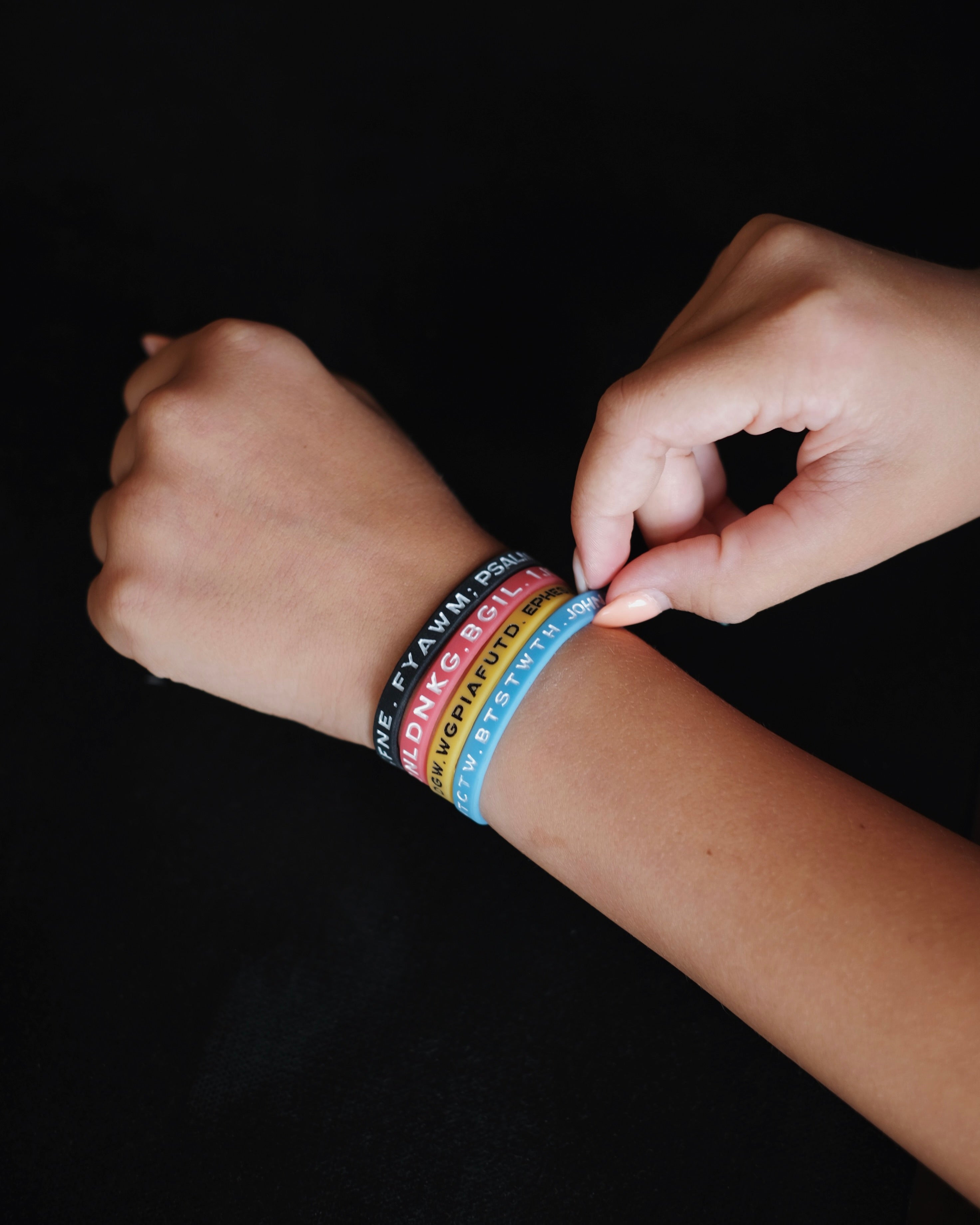 Four Bible Memory Project wristbands on a wrist