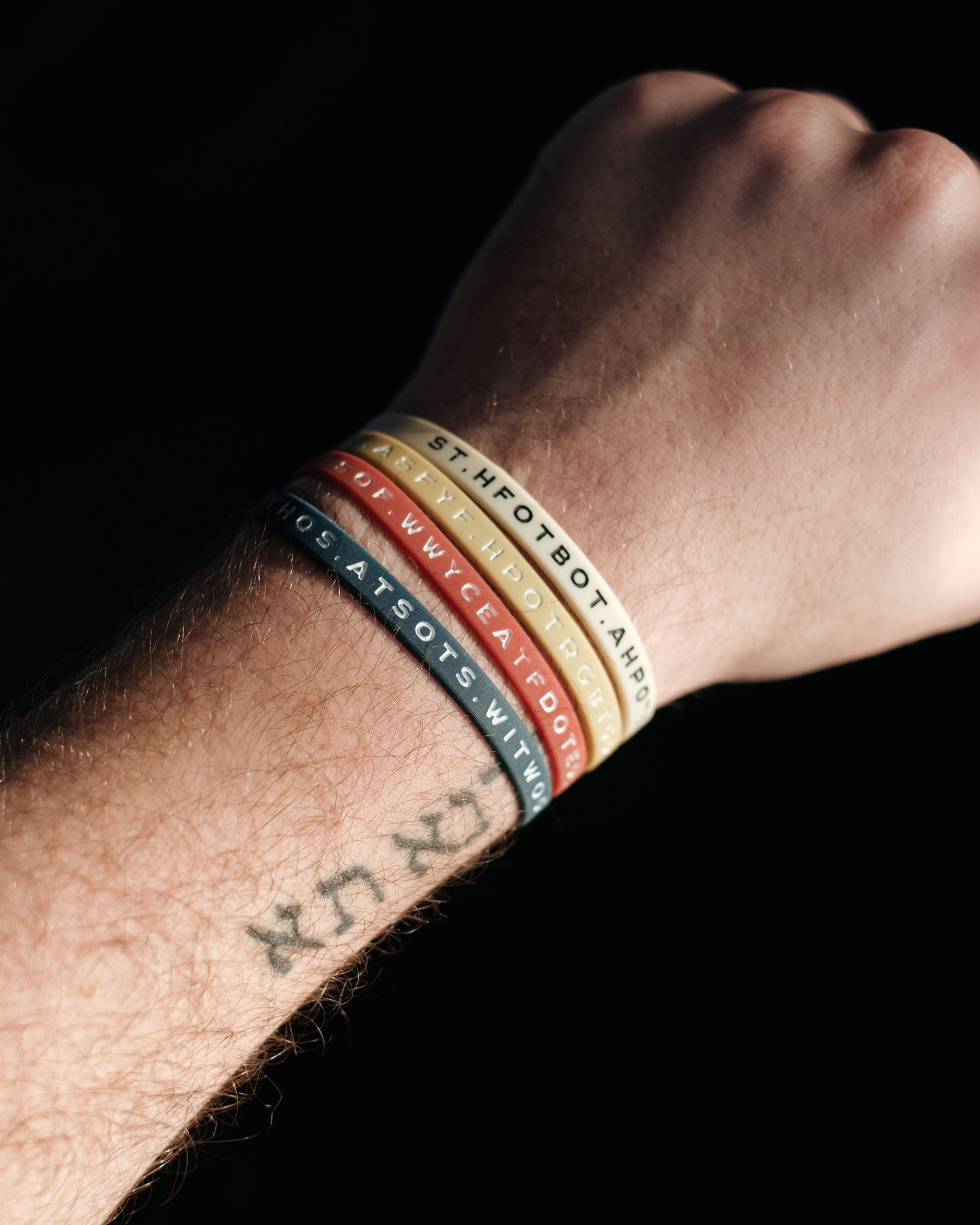 Four Bible Memory Project wristbands on a wrist