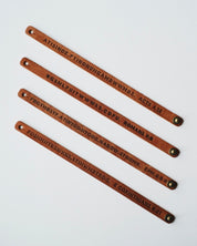 Four dark leather wristbands