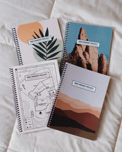 Four Bible Memory Project journals on a bed