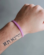 Pink Bible Memory Project wristband on a wrist